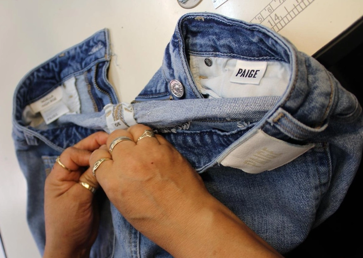 Tailor performing expert casual wear alterations on jeans and shirts in our Phoenix workshop.